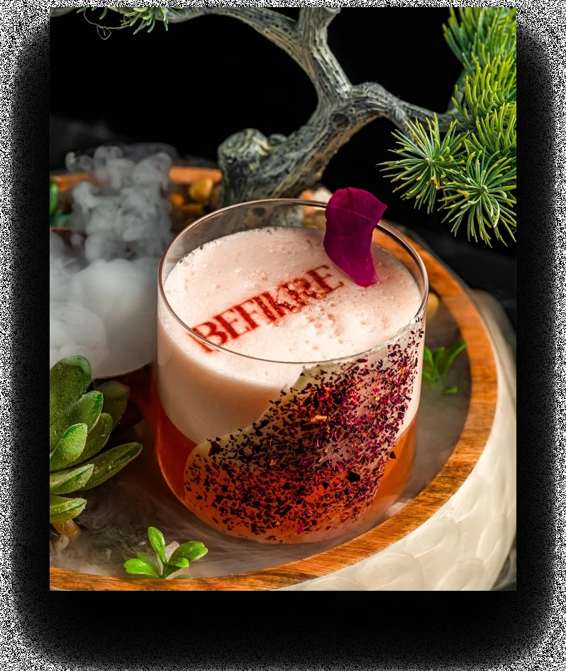 Befikre signature cocktail topped with foam and a rose petal